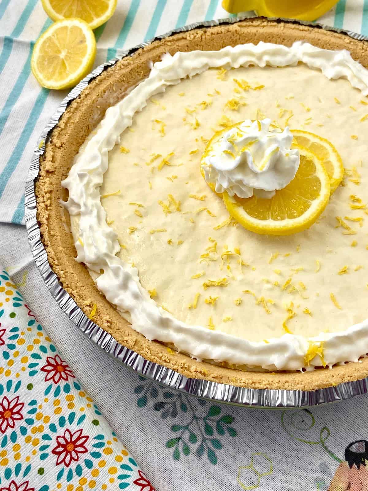Lemon Icebox Pie with lemons and whipped cream.