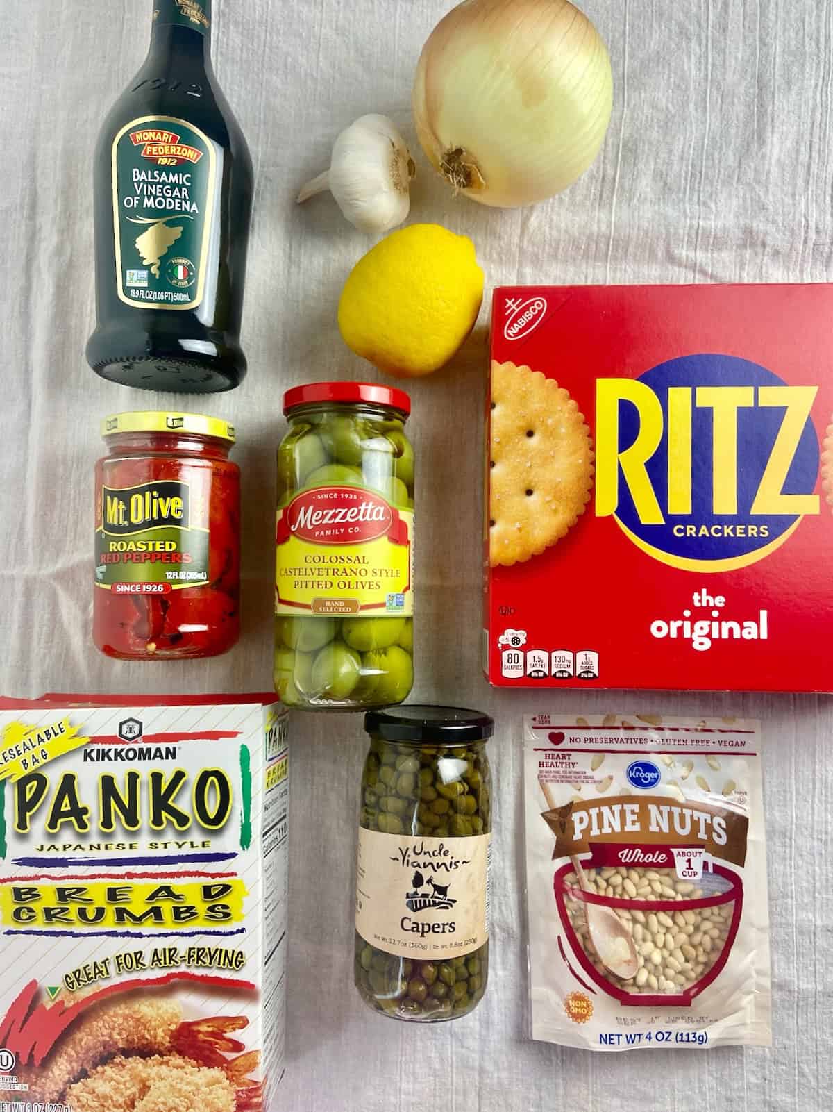 Sicilian baked cod ingredients on white table.