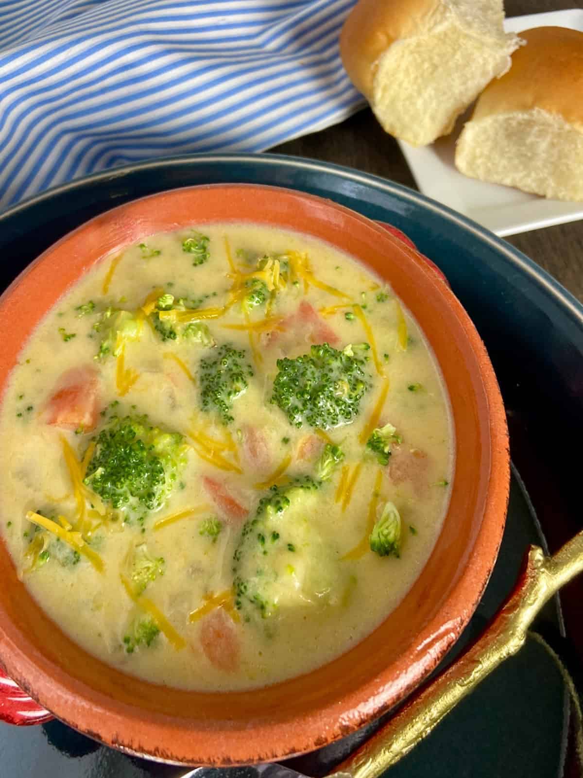 Close up image of broccoli soup in red bowl.
