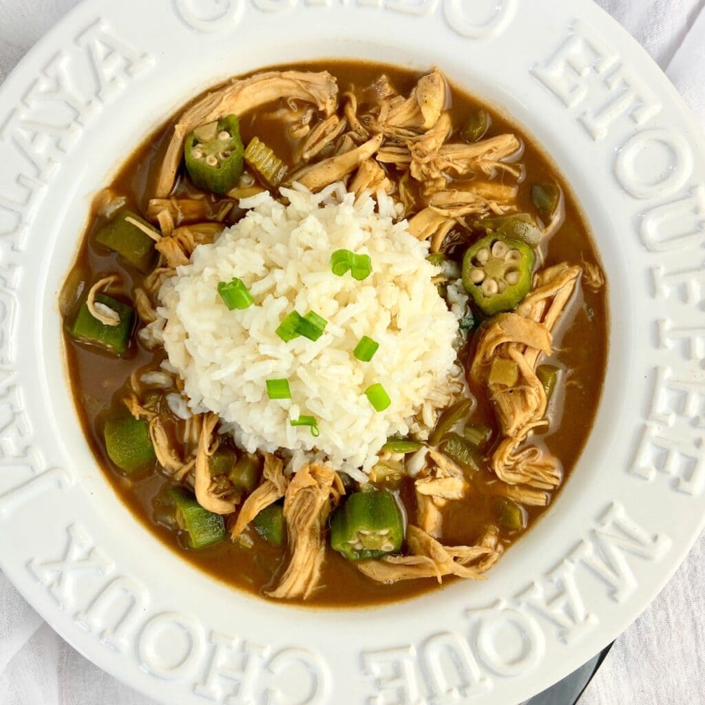 Chicken Gumbo with a scoop of rice in a white bowl.