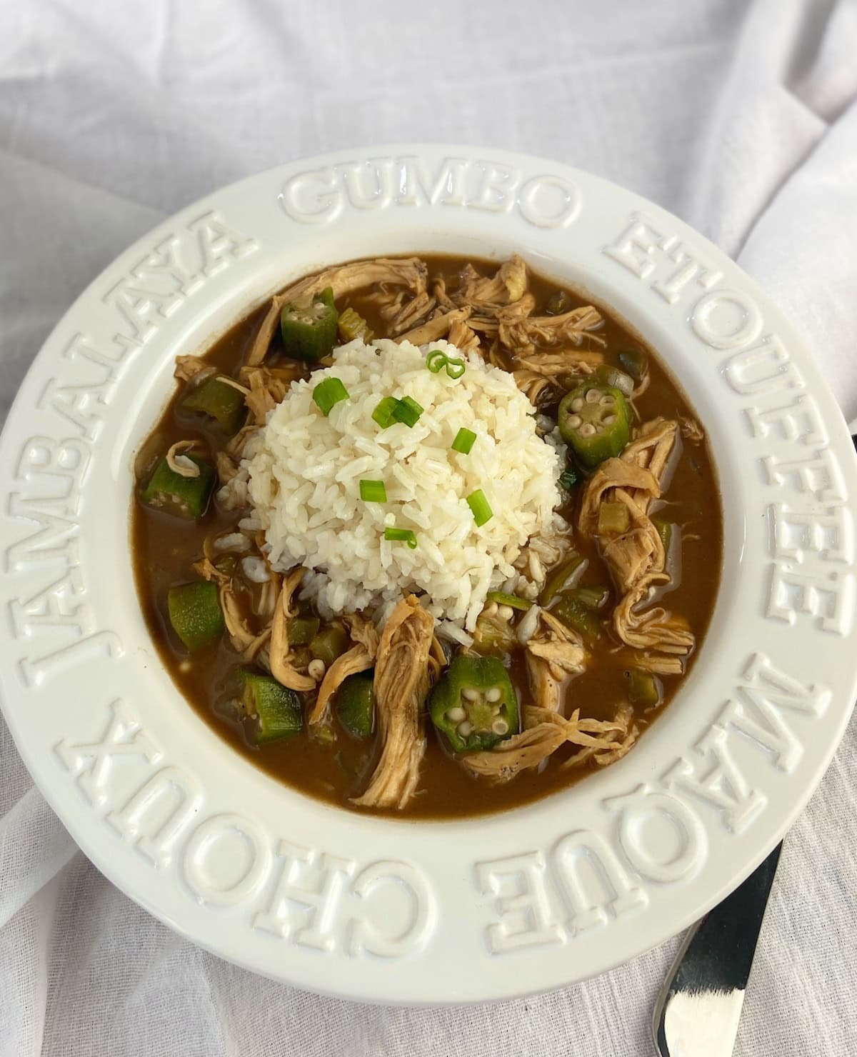 Chicken gumbo with rice in white bowl.