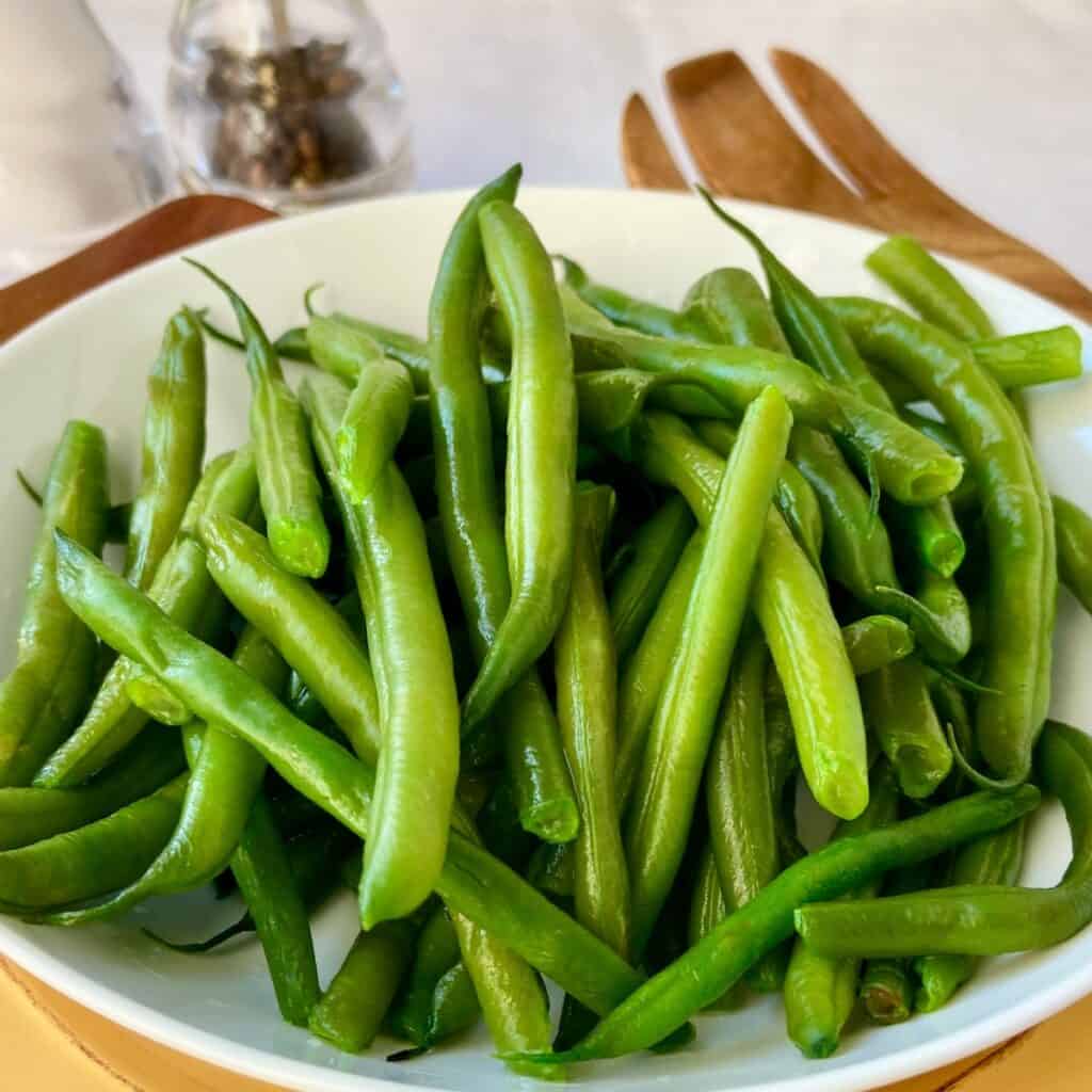 Perfect boiled green beans in white bowl.