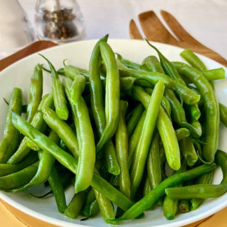 Perfect boiled green beans in white bowl.