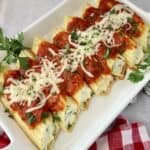 Manicotti shells topped with red sauce and Mozzarella cheese.