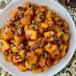 Roasted cubes of butternut squash in a white serving bowl.
