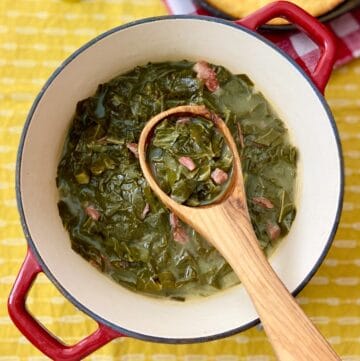Stockpot with collard greens and a wooden ladle.