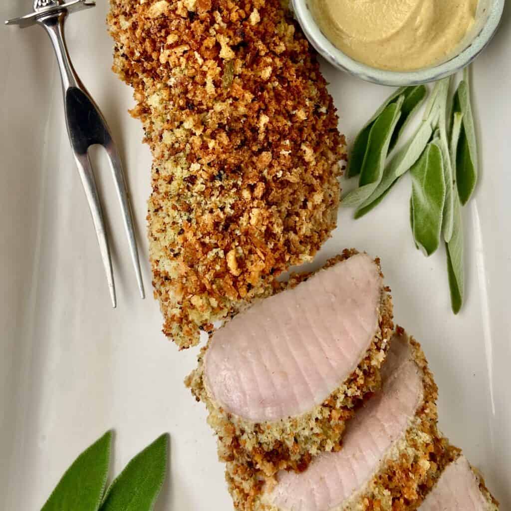 Panko Crusted Pork Tenderloin on white serving platter with a side of Dijon mustard.