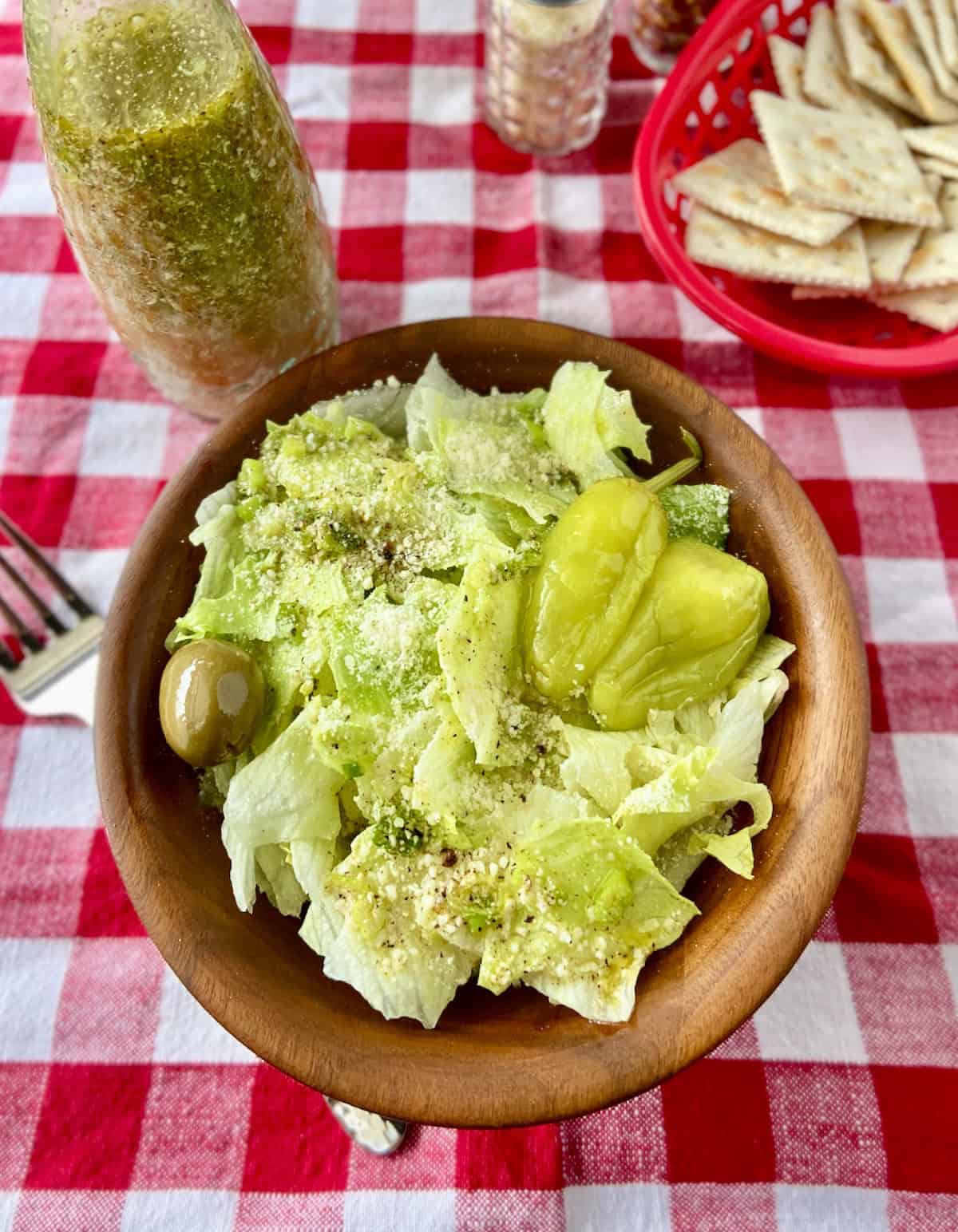 Campisi's salad dressing on iceburg lettuce in wooden bowl.