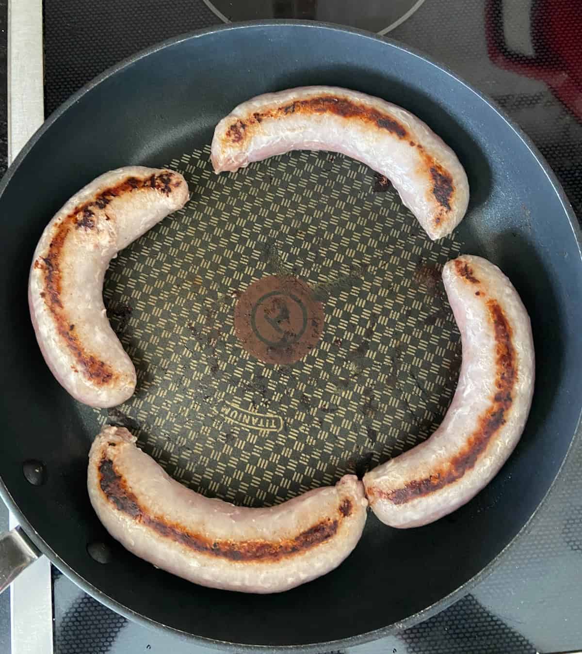 Irish bangers browning in skillet.
