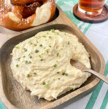 Irish Pub Cheese on wooden platter with knife spreader.