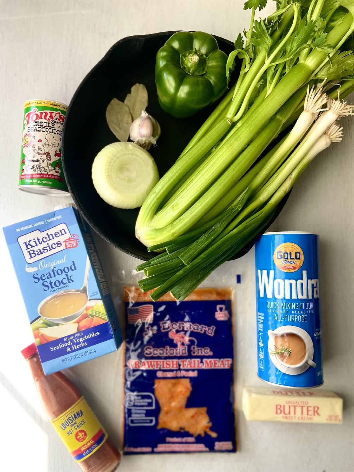 Ingredients for crawfish etouffee on white wooden table.