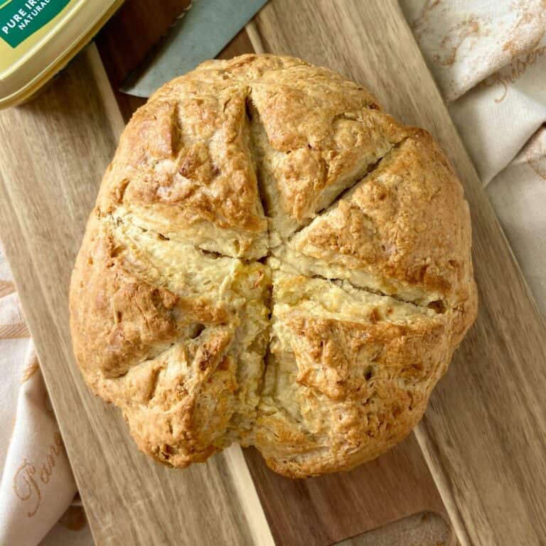 Round loaf of Irish soda bread scored on top.