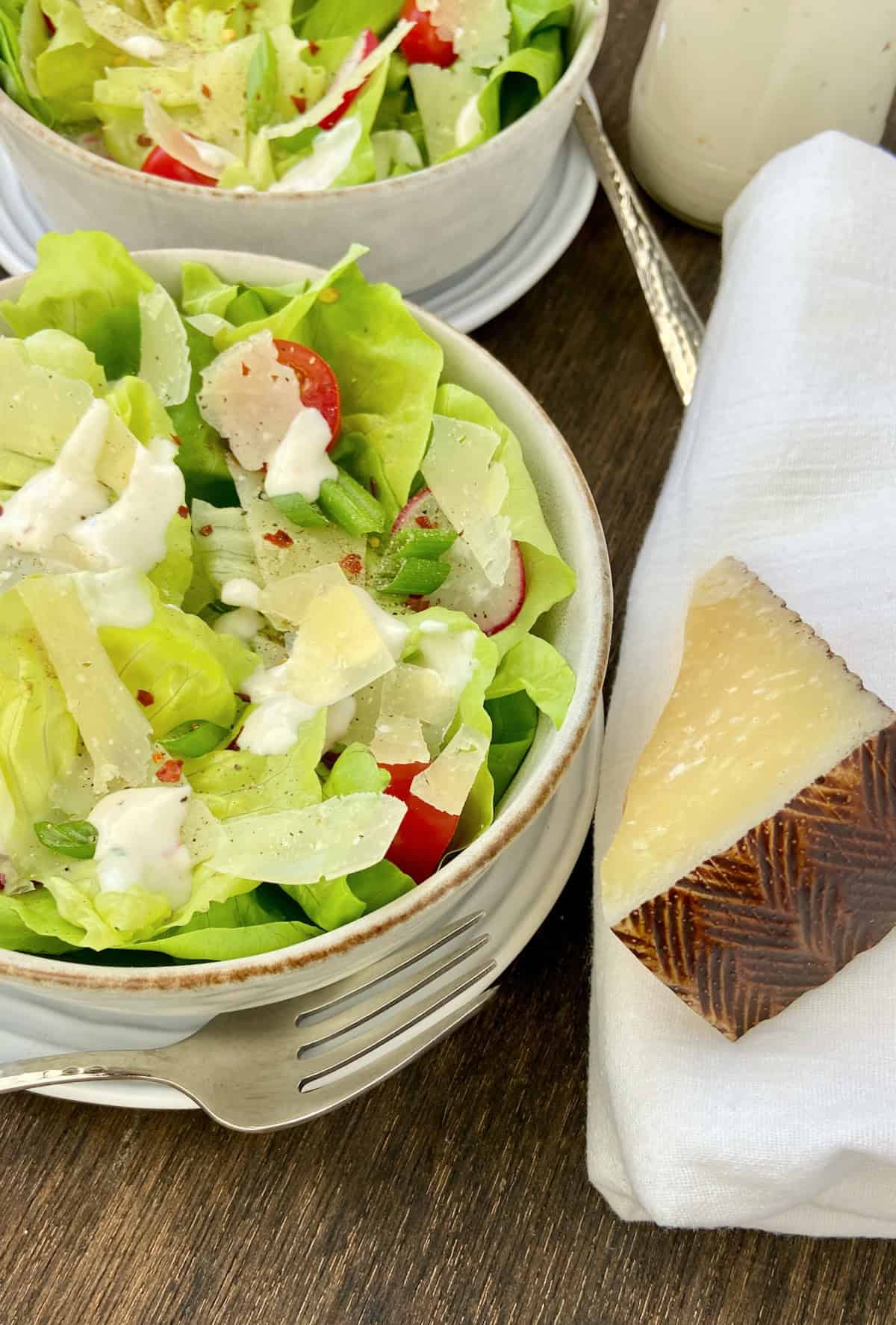 Shaved Manchego cheese shards on Bibb salad.