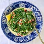 Mediterranean style creamed spinach and arugla in a decorative blue bowl.