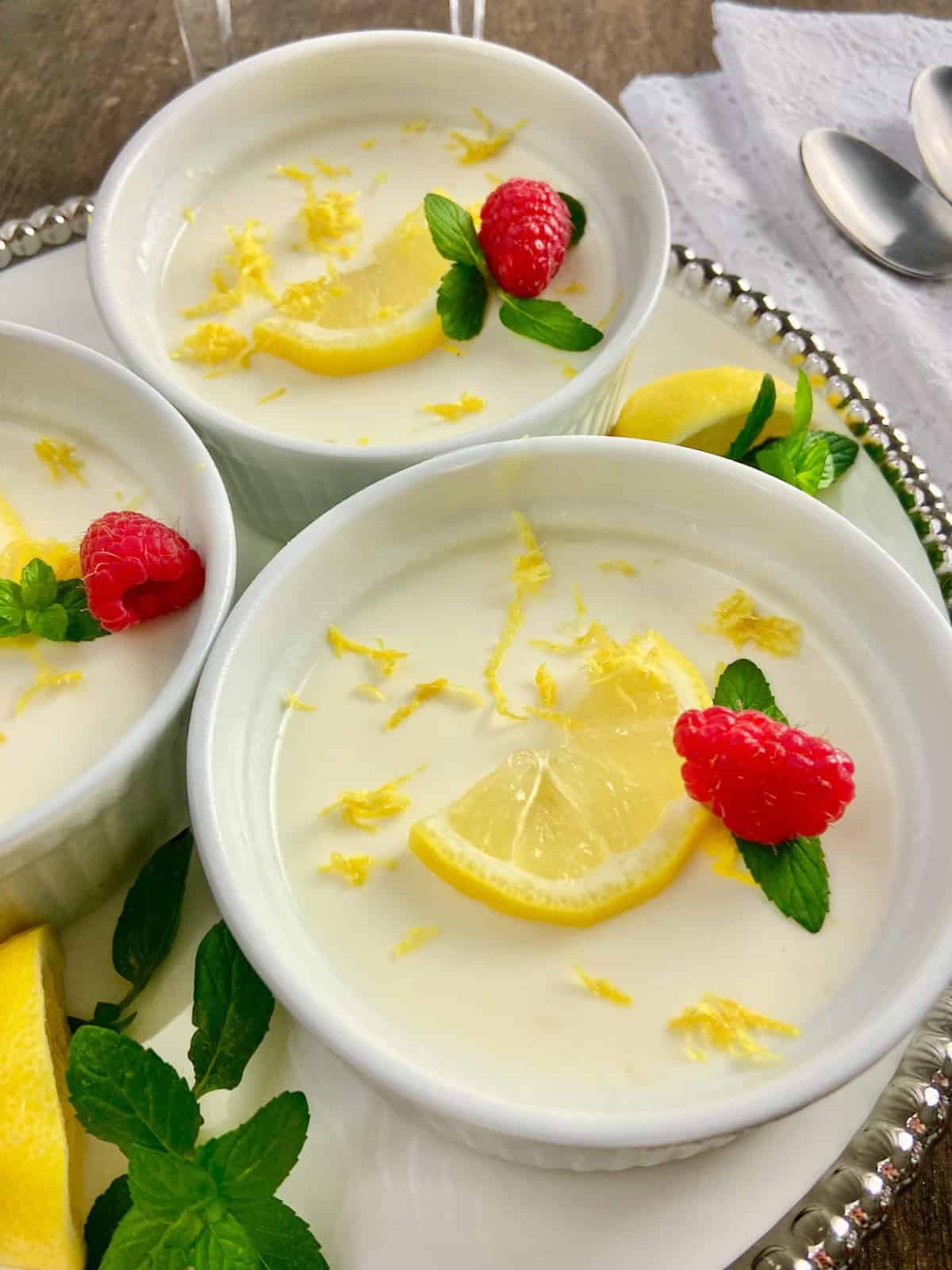 Lemon Panna Cotta in ramekin with mint and lemon garnishes.