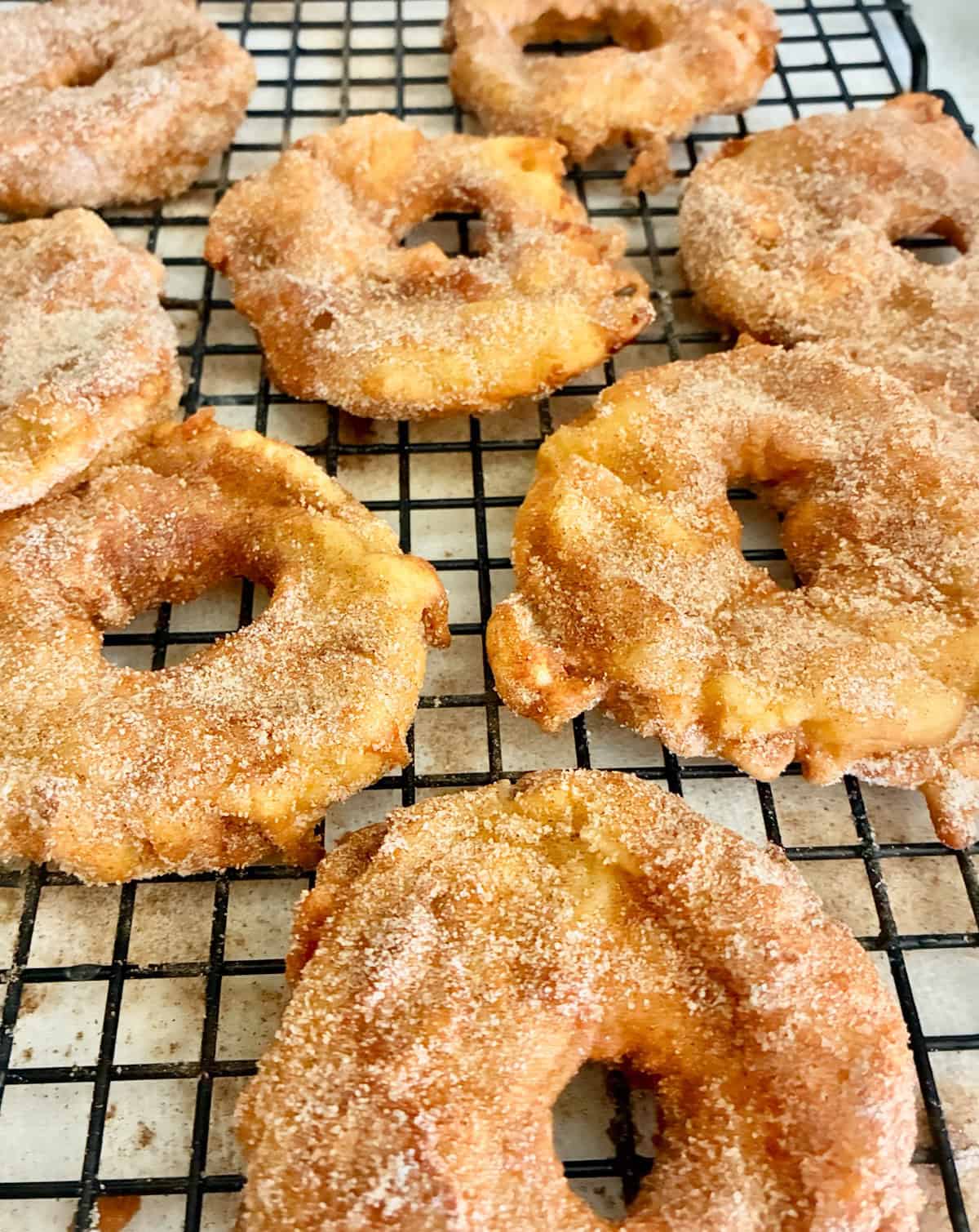 Fried German Apple Rings on a wire rack.