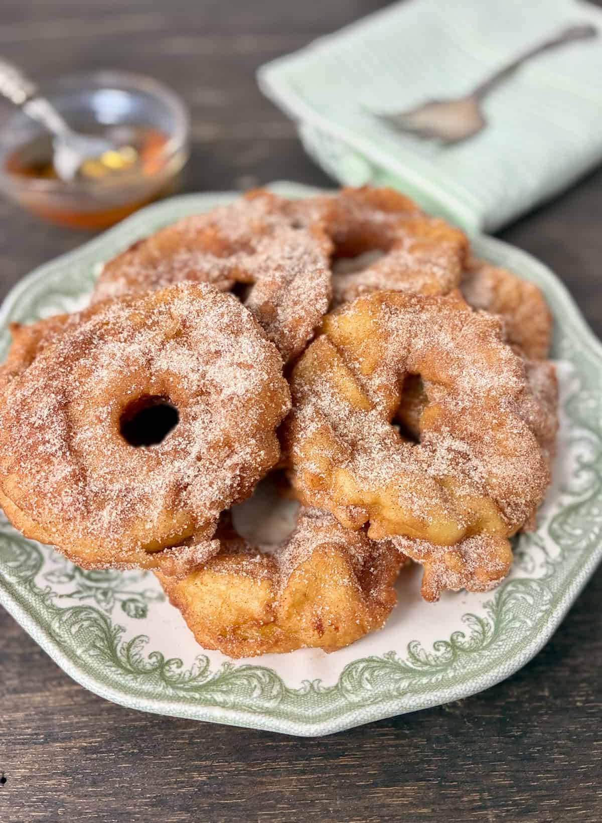 Apple rings coated with sugar cinnamon on vintage serving plate.
