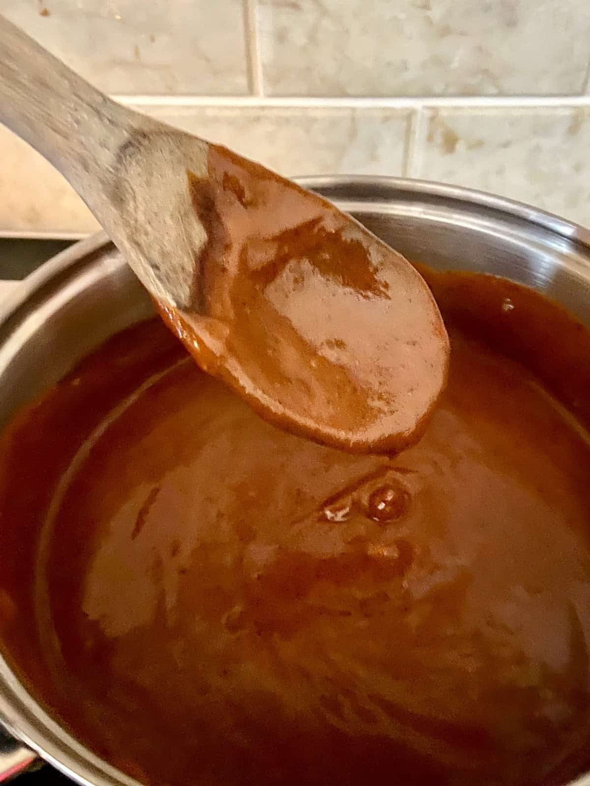 Red Enchilada Sauce on wooden spoon.